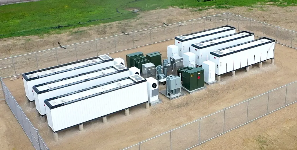Batterijcontainers en transformatoren van een energieopslagsysteem achter een hek